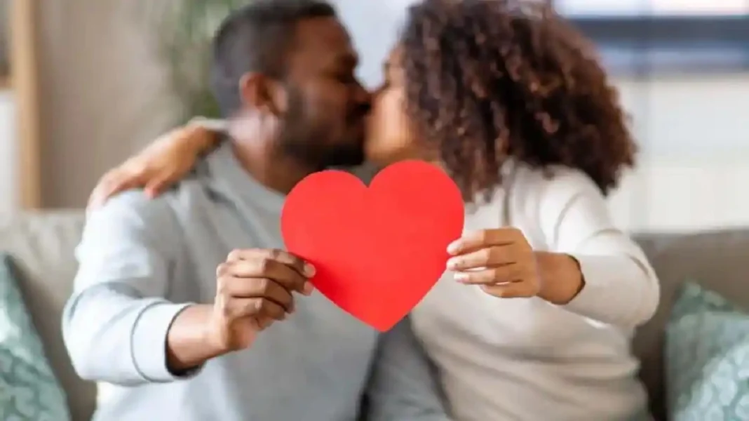 un couple en train de s'embrasser et tenant un cÅ“ur rouge